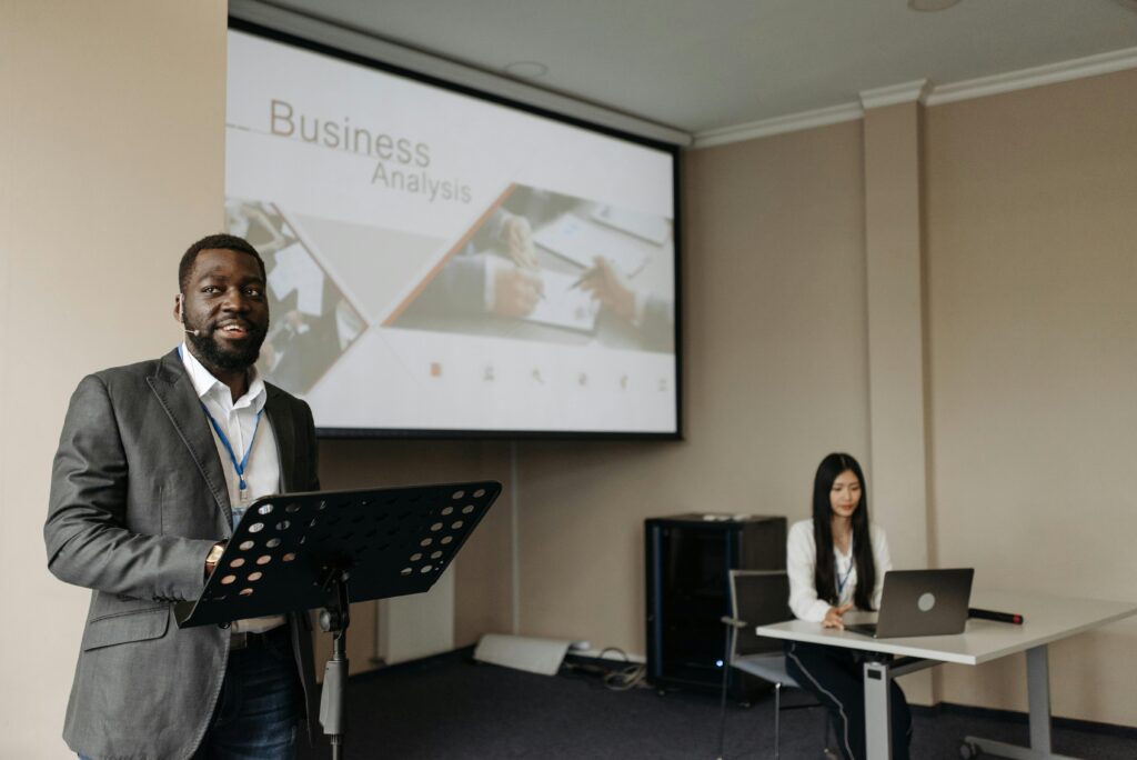pexels-photo-8761332-8761332 Business professionals presenting with projector and laptop in modern office.